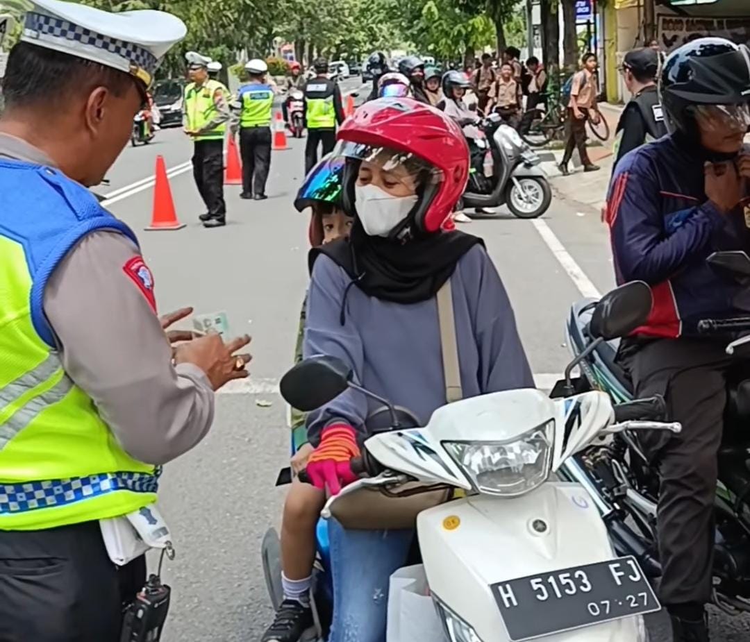 Petugas Satlantas Polres Kudus tengah memberikan apresiasi kepada pengendara motor yang tertib berlalu lintas (Foto: Dok Satlantas Polres Kudus)
