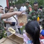 Babinsa Serka Putut Tetuko bersama rekan-rekannya membagikan pakaian pantas pakai dan sembako, Jumat (14/04)