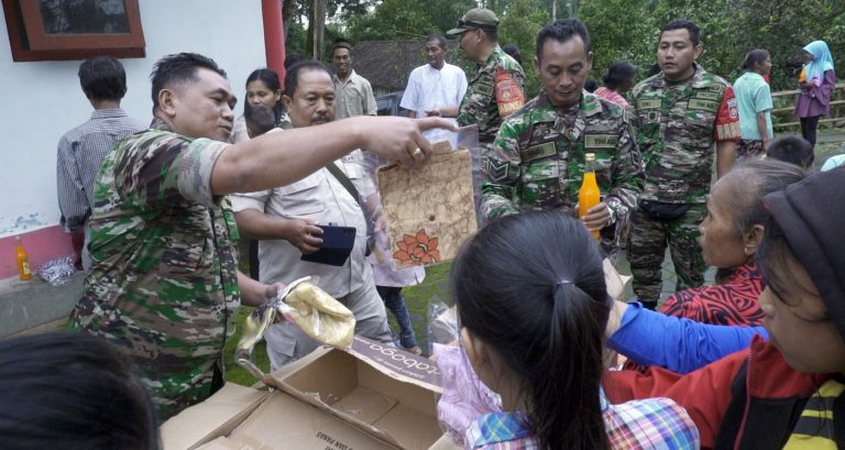 Babinsa Serka Putut Tetuko bersama rekan-rekannya membagikan pakaian pantas pakai dan sembako, Jumat (14/04)
