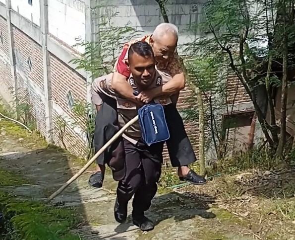 Bertugas Saat Puasa, Polisi Ini Gendong Lansia ke Gereja