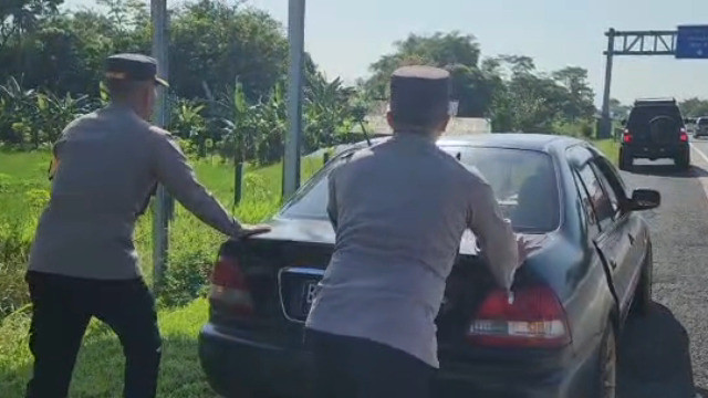Aksi Kapolres dan Wakapolres Boyolali mendorong mobil mogok di tol Semarang - Solo daerah Boyolali, Kamis (20/04).