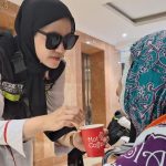 Petugas menyuapi jemaah haji lansia dengan minuman full cream