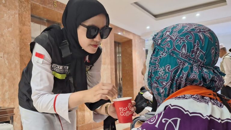 Petugas menyuapi jemaah haji lansia dengan minuman full cream