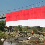 Kolaborasi SMK MIPHA, BPBD dan FPTI Bentangkan Bendera Merah Putih di Jembatan Gantung