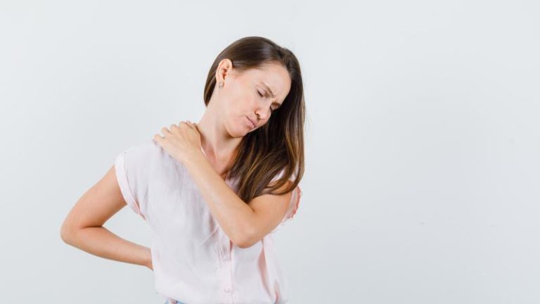 098947700_1666685245-young-woman-suffering-from-back-pain-t-shirt-skirt-looking-tired-front-view